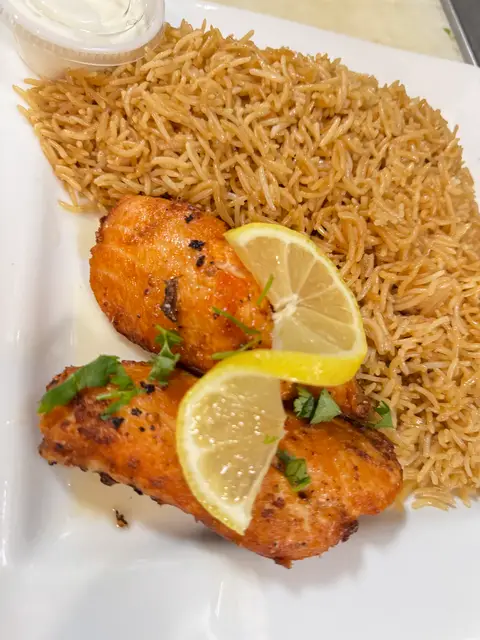 Grilled salmon fillet served with rice and salad